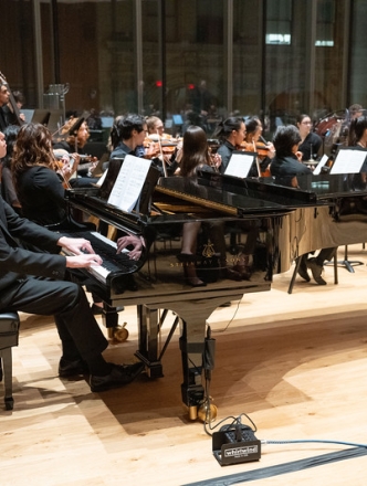 Full orchestra playing with piano prominently in front