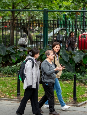 Professor Weinstein walking with 2 female students in Washington Square Park
