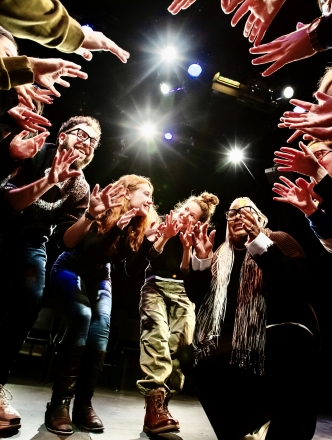 Camera shooting up at drama therapy students standing in a circle