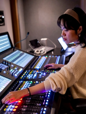 Student working in Music technology lab with lit up equipment