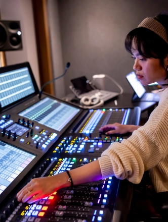 Student working in Music technology lab with lit up equipment