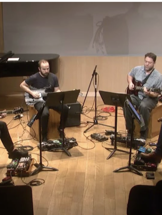 Four electric guitar musicians sitting in circle playing music