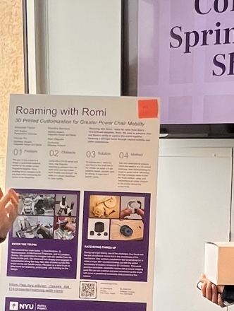 Student presenting a poster on 3D printing for assistive technology to showcase attendee