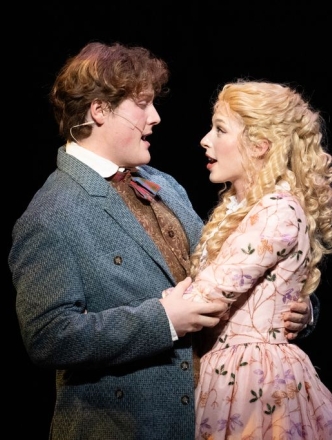 Two singers hugging and singing while looking into each others eyes lovingly.