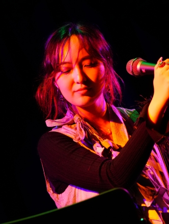 Student at Microphone in pink lighting