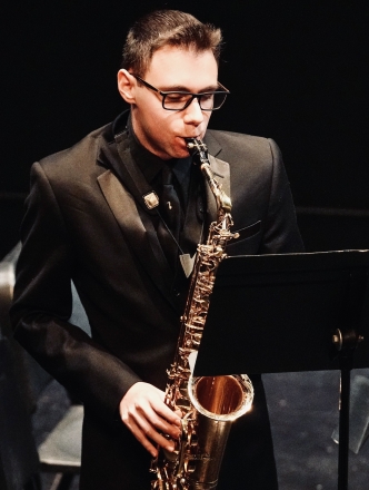 Student playing the saxaphone on stage
