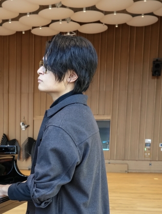 Student performing on piano in Pauslon Center before live audience