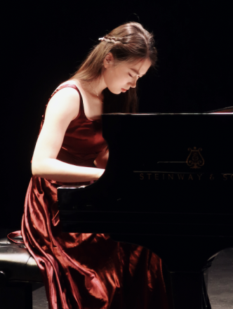 Piano student in red velvet gown performing in Black Box Theatre
