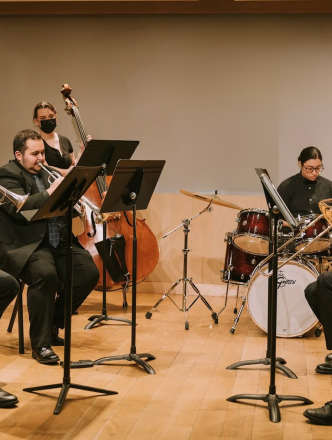 Group of students practicing brass, bass and drums in studio