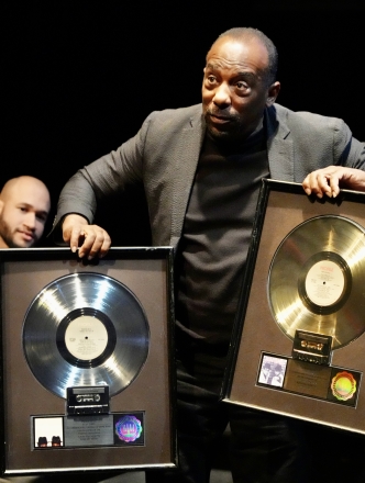 Man holding up a gold and platinum album