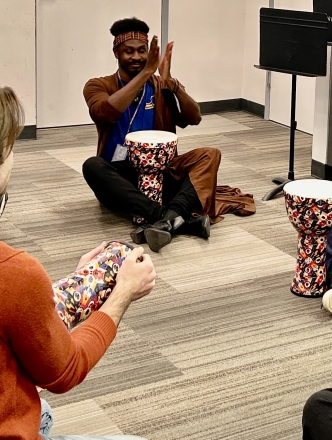 Students sitting on floor with instructor and instruments