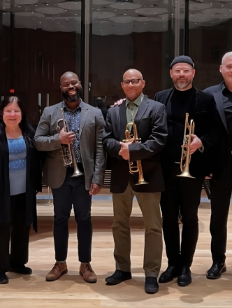 Eight NYU Brass studies faculty lined up for group pic