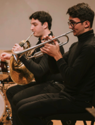Two brass students practicing instruments