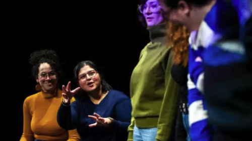 Professor coaching two students acting on stage