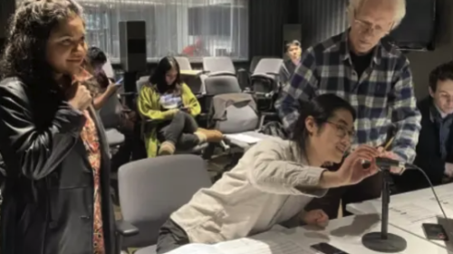 Professor working with students in an audio lab